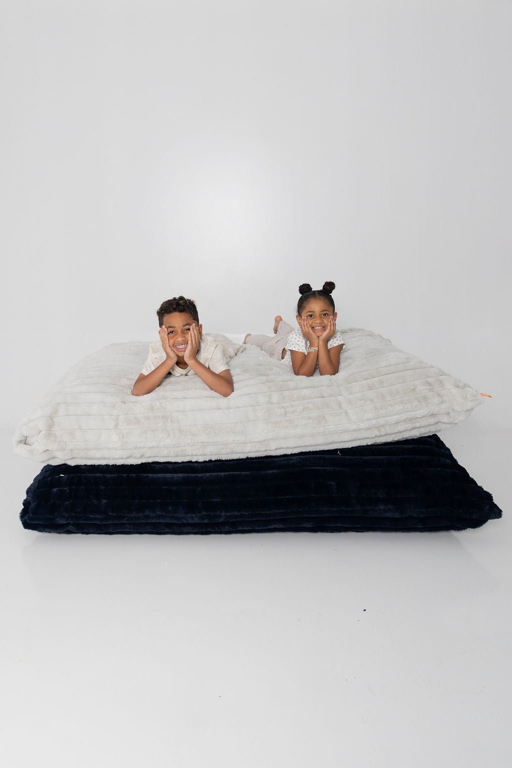 Two kids resting their chins on stacked Baggies