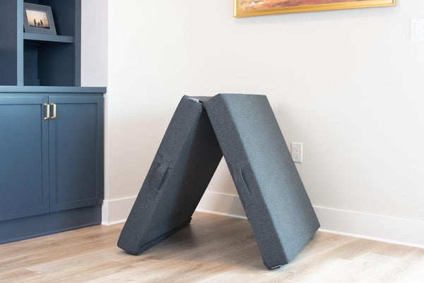 Two Figgy Velcro Base square cushions in charcoal flatweave configured as an A-frame arch in a living room