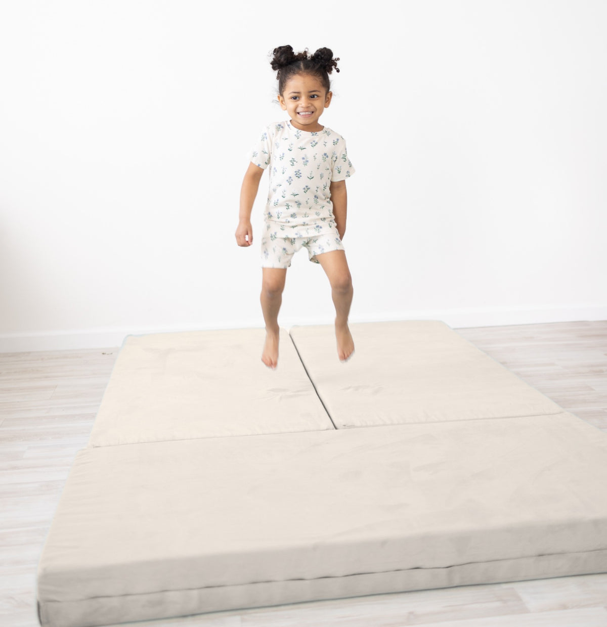Girl jumping on Figgy Adventure Mat in Fawn Beige luxe velvet