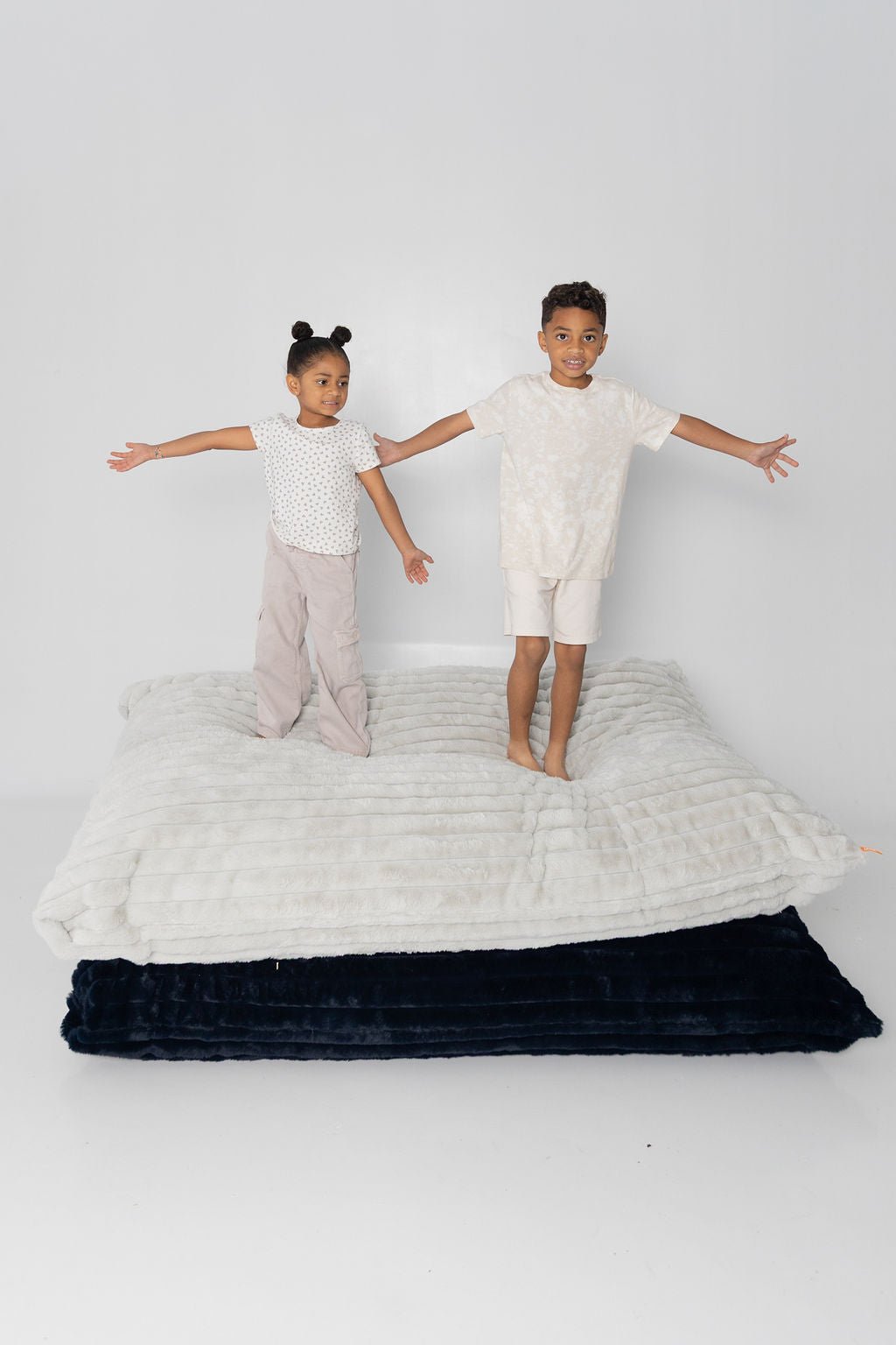Two kids balancing on stacked Baggies, arms out