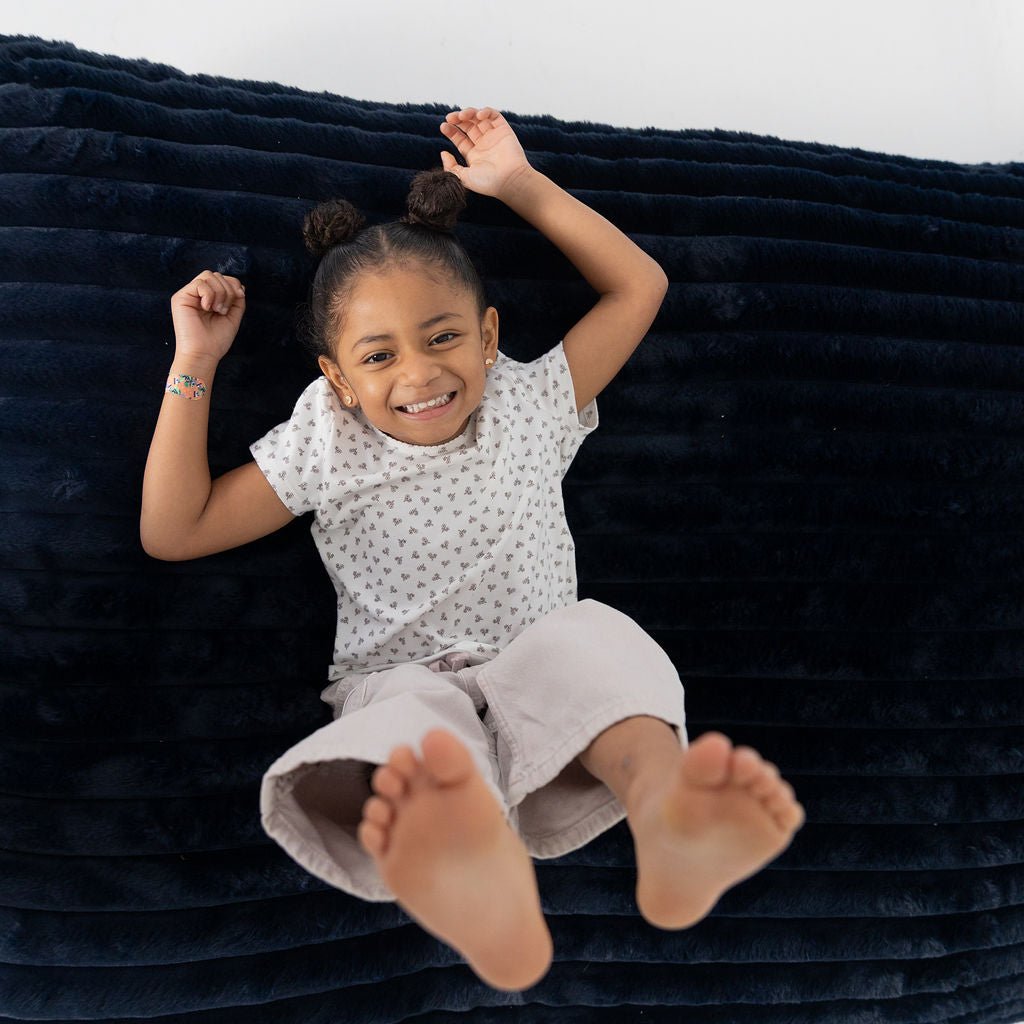 A girl laughing on her back on a Night Owl Baggy